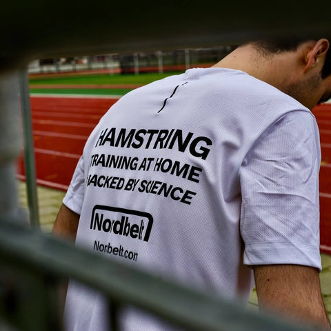 Hamstring Training at Home shirt on the athletics track