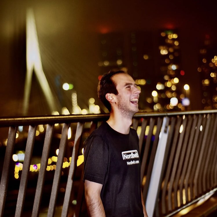 Lachende sporter op de Erasmusbrug bij nacht
